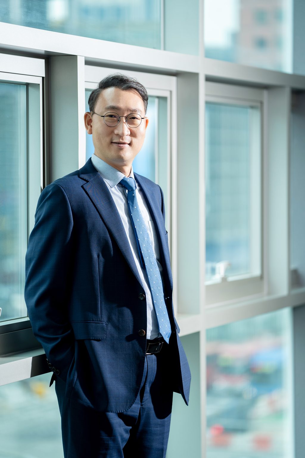 법무법인 명진 김우석 대표변호사가 사무실 창가에 정장 차림으로 서 있는 모습